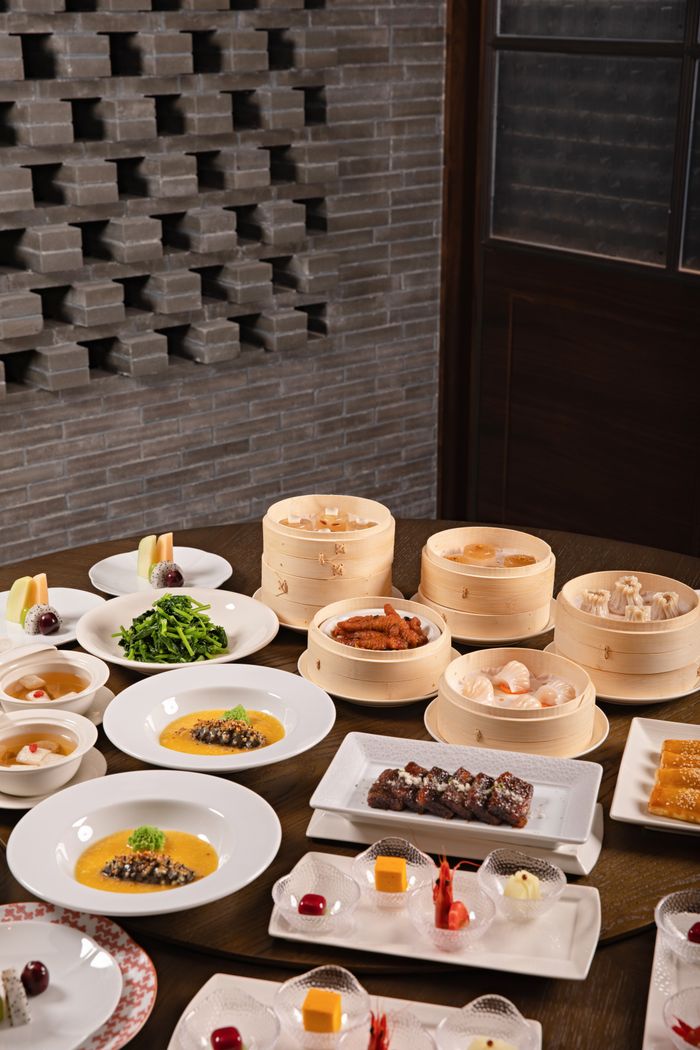 our-journey-01 A variety of Chinese dishes including dim sum on a beautifully arranged dining table.